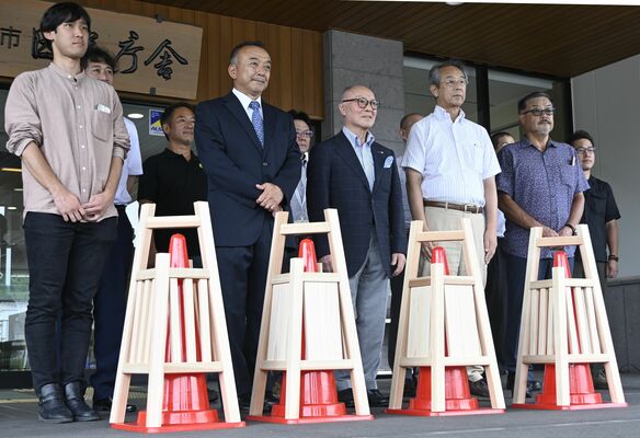 完成した木製コーン標識の試作品と関係者ら