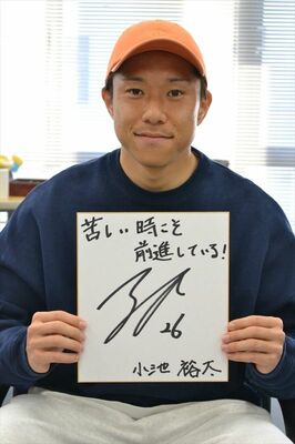 サイン色紙を手にする小池選手。若者に向け「苦しい時こそ前進している！」とメッセージを寄せた