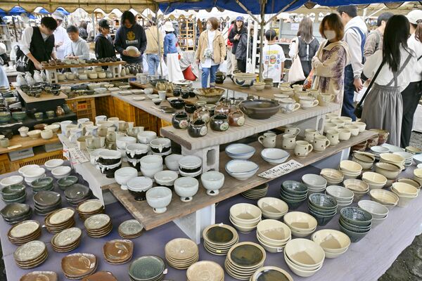ずらりと並んだ陶器を品定めする来場者＝29日午後０時５分、益子町益子