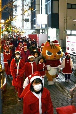 サンタの格好をして歩く参加者ら