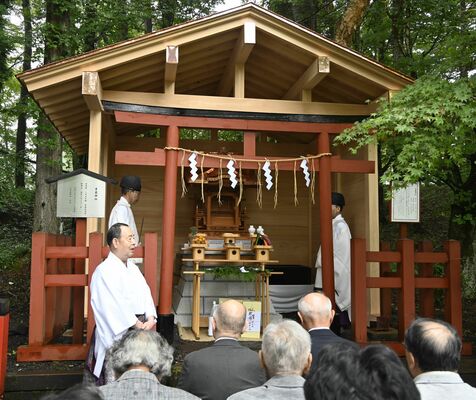 荘厳に生まれ変わった華厳神社の前であいさつする斎藤権宮司（左）