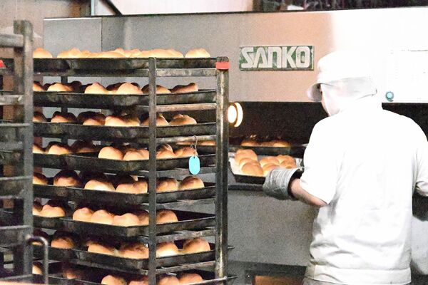 給食用のハニーロールを焼くパン職人＝４月下旬、宇都宮市上金井町