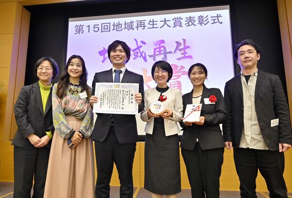表彰式で笑顔を見せるそらいろコアラ共同代表理事の増田さん（中央左）と鳥飼さん（同右）ら＝27日午後４時５分、東京都港区