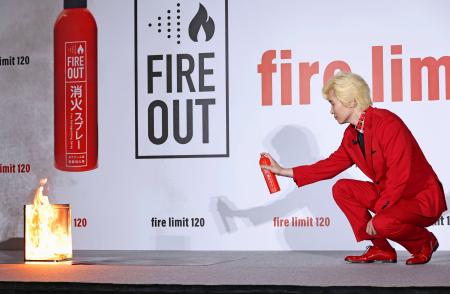 　消火スプレーを使って火を消すカズレーザー＝８月２６日、東京都新宿区