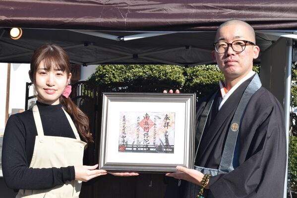 「徳川家康公祈念御朱印」を持つｕｍｉさん（左）と桑門副住職（右）