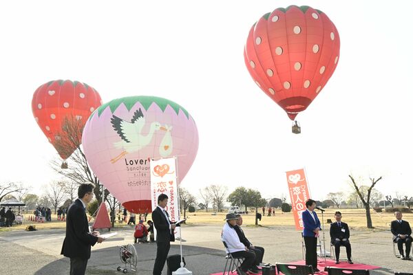 コウノトリやイチゴをデザインした気球が浮かぶ会場で行われた式典