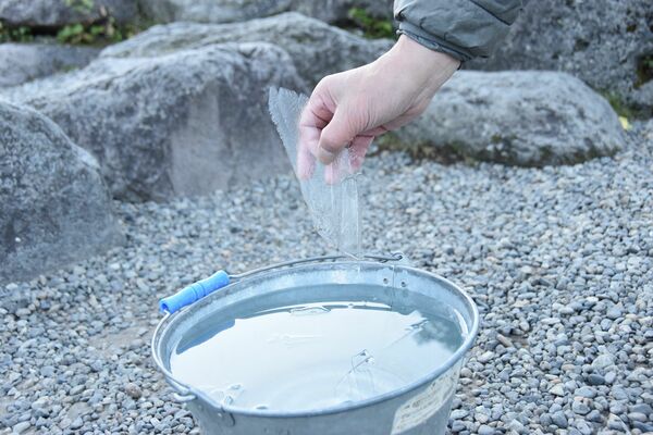 観測用のバケツに薄く張った氷＝１日午前６時55分、日光市中宮祠