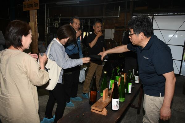 コンサートの休憩中、参加者に日本酒を注ぐ渡邊社長（右）＝５月17日、日光市