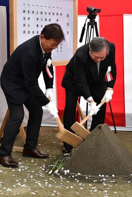くわ入れをする高木邦格理事長（右）と鈴木康裕学長