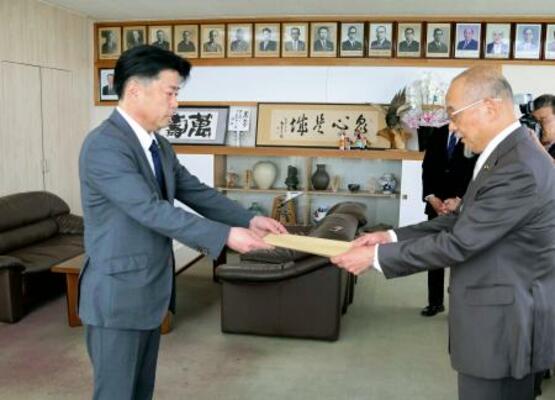 市議会議長に辞職届を提出する福岡県田川市の村上卓哉市長(左)=25日午前、田川市役所