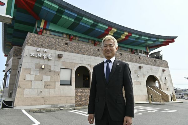 国道50号沿いに立地する小山店の前に立つ廉社長＝小山市