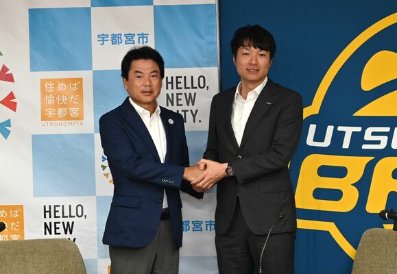 握手を交わす栃木ブレックスの藤本社長（右）と佐藤宇都宮市長＝１日午後、同市役所
