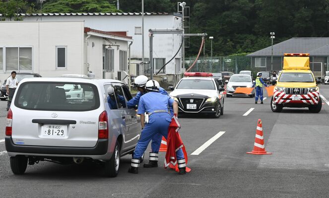 逆走した想定の車を止めて運転手に話しかける県警高速隊の隊員ら＝６日午前、那須町高久甲