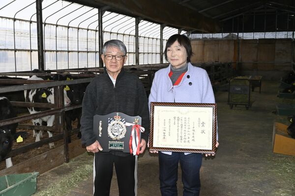 最優秀賞のトロフィーを持つ手塚社長（左）と妻の優子さん＝さくら市