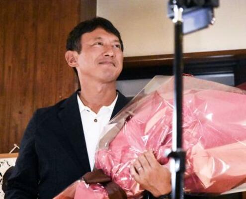 　熊本県八代市長選で初当選を果たし、花束を手に笑顔の小野泰輔氏＝３１日夜、八代市
