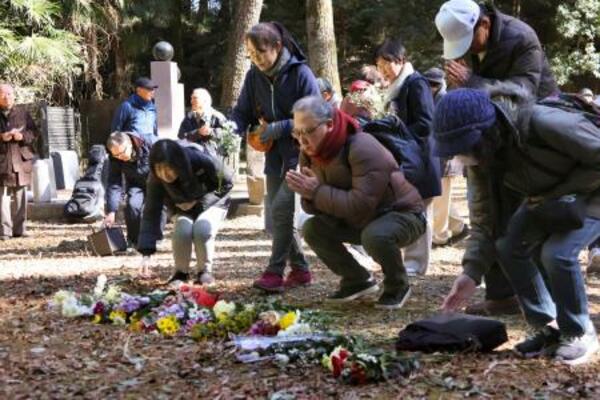 県立公園「群馬の森」の朝鮮人追悼碑の跡地で花を手向ける参加者ら=31日午後、群馬県高崎市