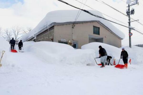 建物の周囲を除雪する人たち=2日午後、青森市
