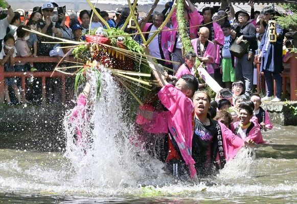 「水飲みの儀」で豪快に神池の水を口に入れる大蛇＝５日午後０時40分、小山市間々田