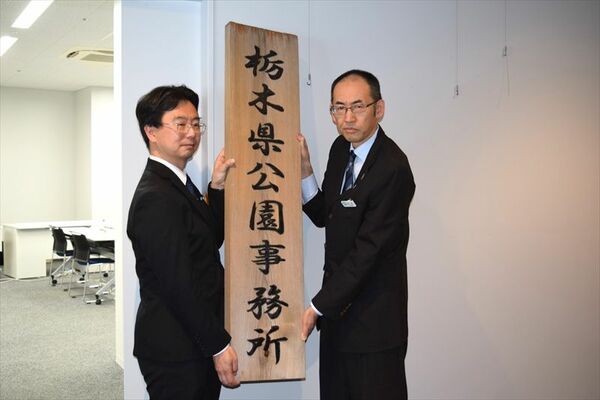 事務所の看板を降納する吉成所長（右）と坂井部長＝27日午前、宇都宮市西川田４丁目
