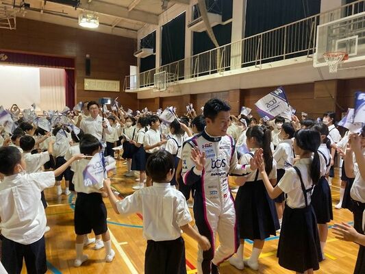 子どもたちとハイタッチする山本選手（中央）