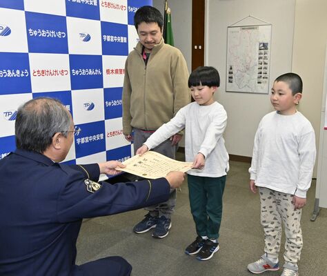本澤署長（左端）から感謝状を受け取る星野玄さん（中央）と弟の丞さん（右端）、父の充さん