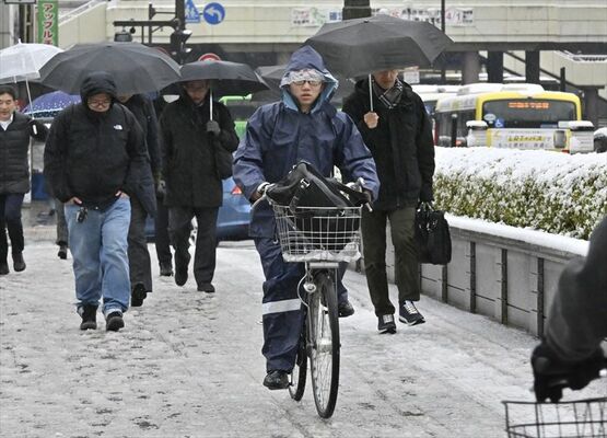 夜間に積もった雪が残る歩道を歩く通勤者＝８日午前７時40分、宇都宮市駅前通り１丁目