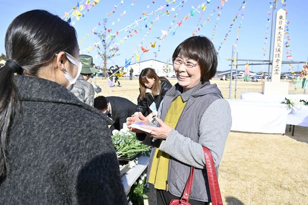 東日本大震災後、初めて「３月11日」を古里で迎え、知人と談笑する武内さん（右）＝11日午後３時、福島県大熊町