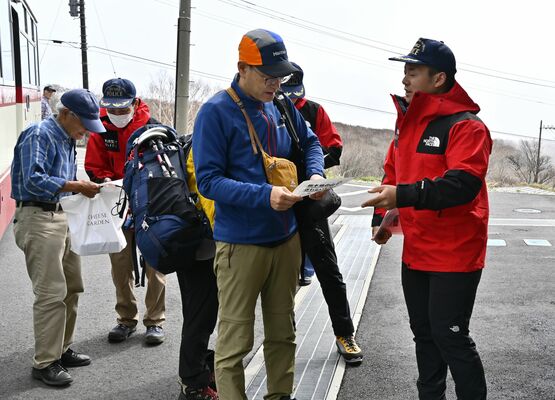 山麓駅を訪れた人にチラシを配る署員ら