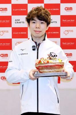 所属先の社員交流会で贈られたケーキを手に、撮影に応じるフィギュアスケート男子の佐藤駿=3日、東京都内