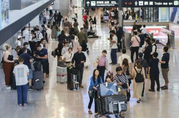 海外から帰国した旅行客らが行き交う成田空港の到着ロビー=8月