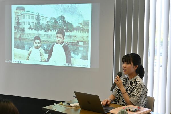被爆者の写真を説明する庭田さん。カラー化の取り組みを「記憶の解凍」と呼んでいる＝１日午後、広島市中区