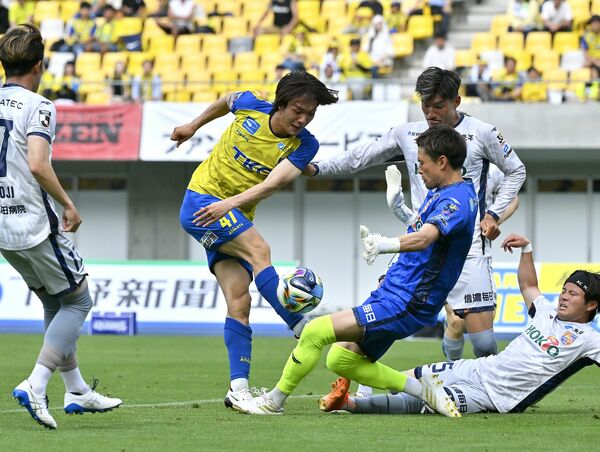 後半39分　ゴール前の混戦で栃木ＳＣのＭＦ吉野（中央）がシュートを放つ＝カンセキスタジアムとちぎ、加藤竜矢撮影