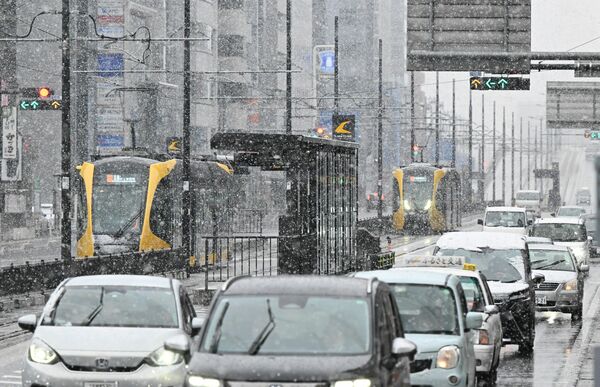 雪の中、行き交う車やLRT=2日午前8時35分、宇都宮市東宿郷2丁目