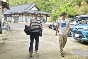 大量のクリを手に作業場に現れた小西さん（左）と園主の水野さん＝13日午前11時40分、那須烏山市中山