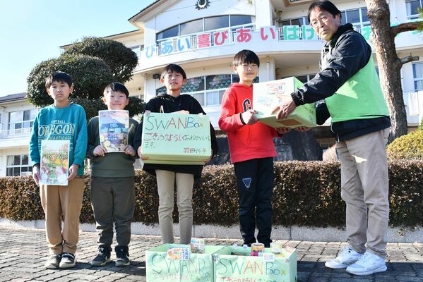 各家庭から集めた食料品が入った「スワンボックス」を寄贈する羽田小の４年生