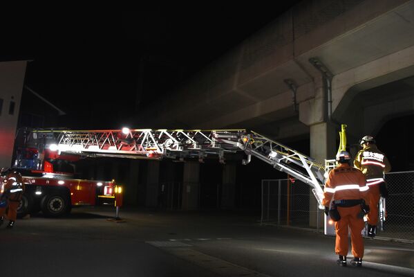 運転を見合わせた電車内からはしご車で移動困難者を救助した東武日光線の現場=11日午後8時40分、栃木市境町