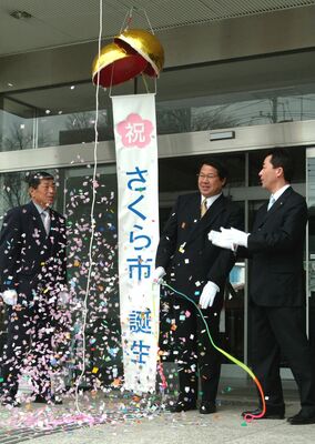 くす玉を割り、さくら市の誕生を祝う関係者（２００５年３月）