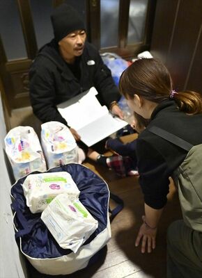 おむつなどを届け果歩さん（右）の相談を受ける小川さん＝１５日夜、宇都宮市内