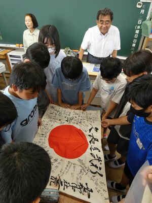 出征者への「日の丸寄せ書き」を手にし、戦時中の暮らしを学ぶ児童ら