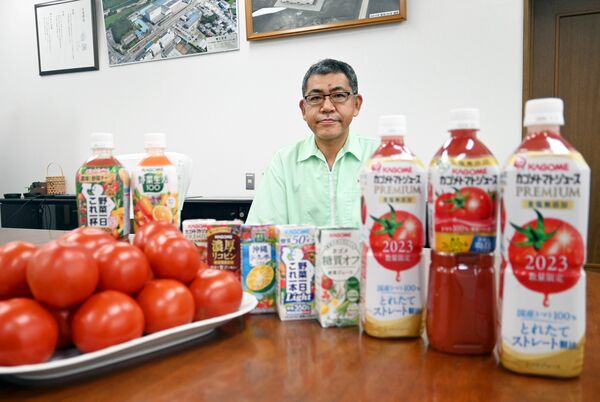 トマトや商品と並ぶ高田工場長