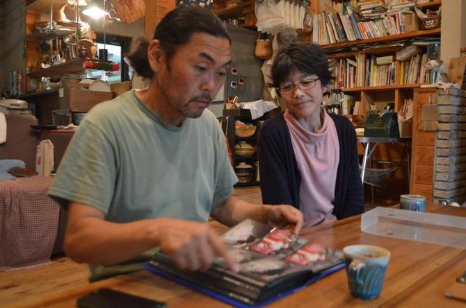 咲楽さん姉妹の幼少期を写真で振り返る力夫さん（左）と悦子さん