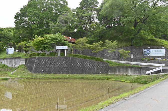 看板が掲げられ、施設が入る小高い丘