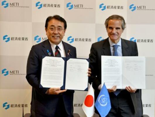 　覚書を締結した赤沢経産相（左）とＩＡＥＡのグロッシ事務局長＝２３日午後、経産省