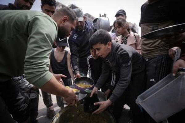 　食料の配給を受ける避難民ら＝１５日、パレスチナ自治区ガザ市（ゲッティ＝共同）