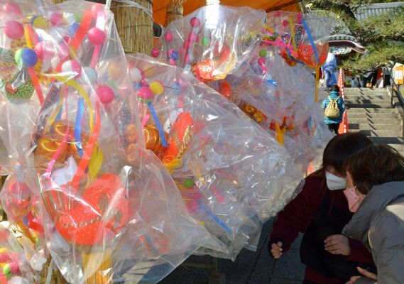 繭玉飾りを品定めする参拝客