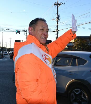 通行人に手を振る大森氏＝23日午前、宇都宮市内