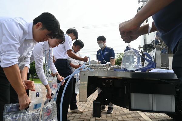 災害時に出動する給水車から飲料水の入れ方などを学ぶ医学生