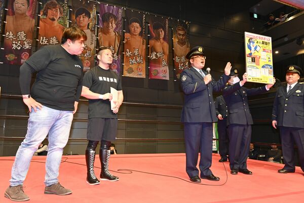 栃木プロレスのリング上で来場者に県警防犯アプリをアピールする警察官ら＝１１日午後、県総合文化センターサブホール
