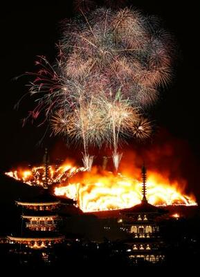 古都奈良の夜空を彩る冬の伝統行事「若草山焼き」。手前は薬師寺の西塔(左)と東塔=24日(午後6時15分から7時16分までの画像19枚を合成)