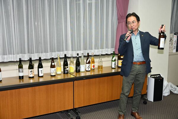 新政酒造の「亜麻猫」を紹介する堀越さん